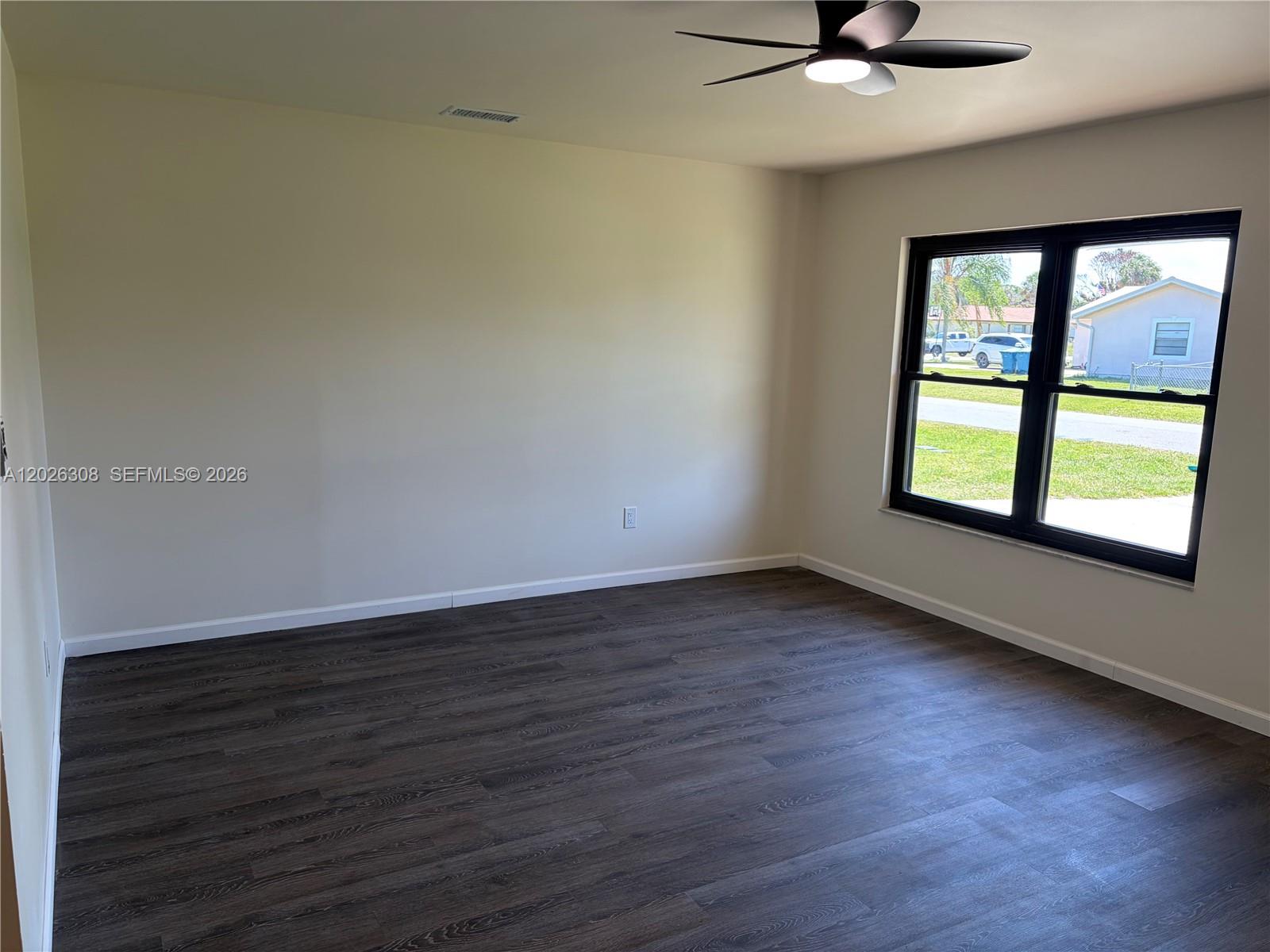 653 Atlas Avenue Northeast Palm Bay, FL 32905 - Photo 4 of 22 wooden floor in an empty room with a window