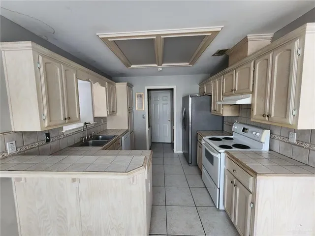 a kitchen with stainless steel appliances granite countertop a sink stove and cabinets