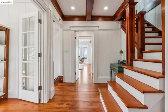 a view of a hallway with wooden floor and staircase