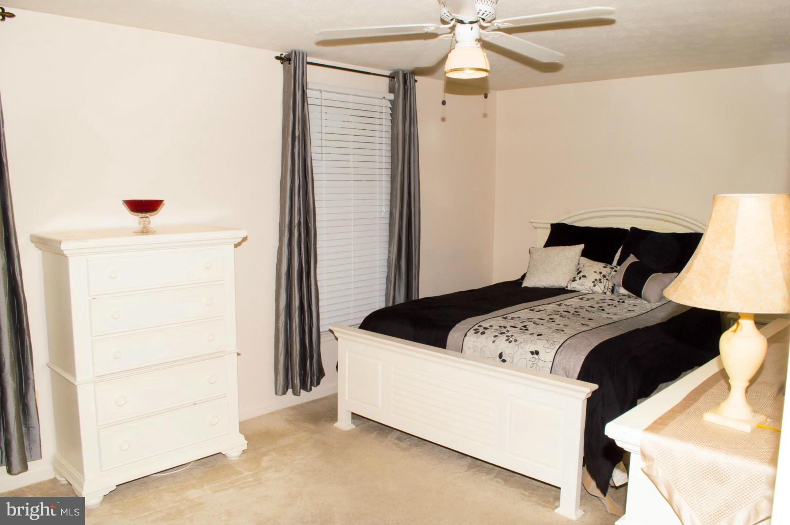 7817 Paddock Way Baltimore, MD 21244 - Photo 14 of 22 a bedroom with a bed and a refrigerator