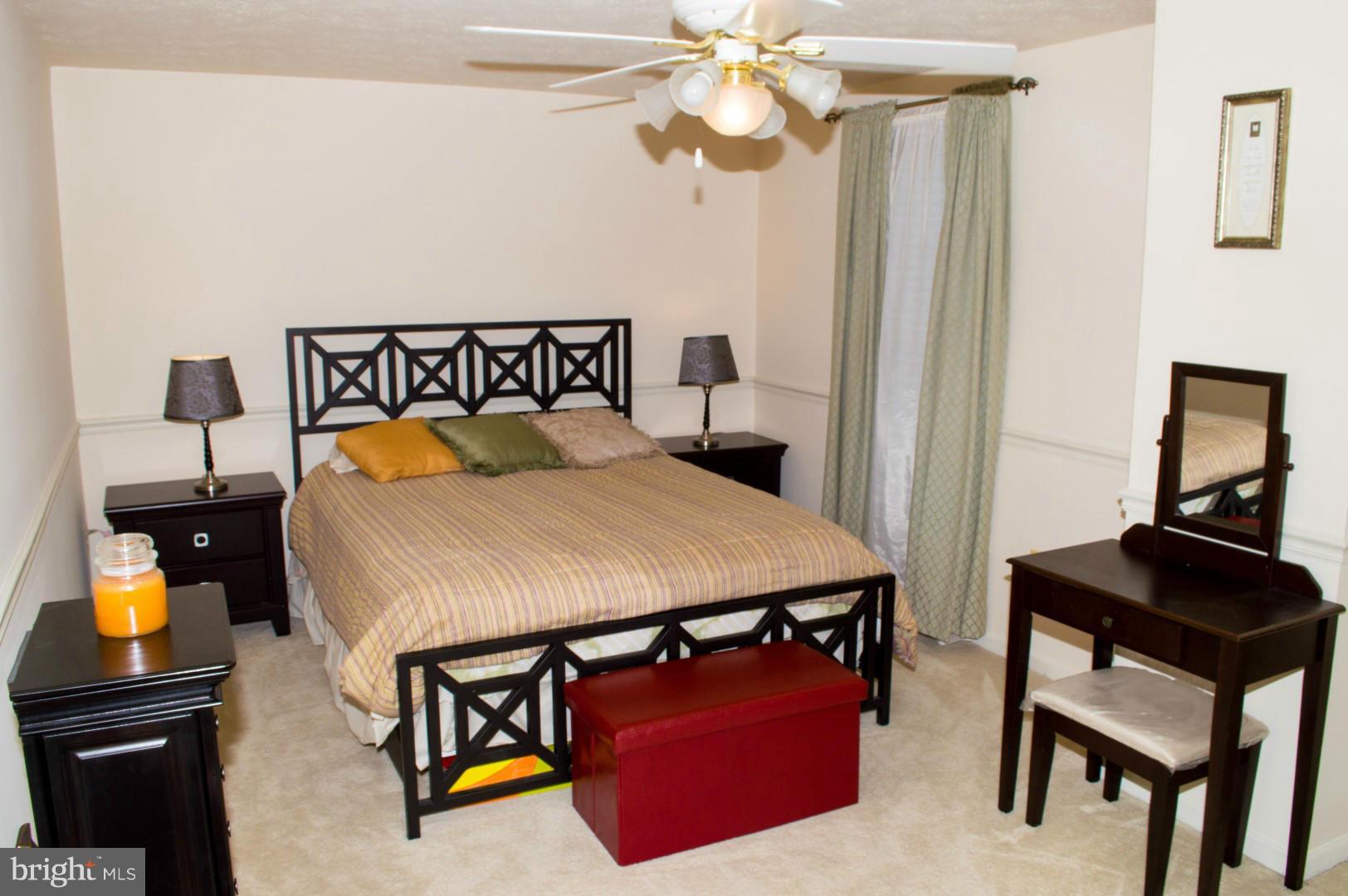 7817 Paddock Way Baltimore, MD 21244 - Photo 15 of 22 a bedroom with a bed and a chandelier