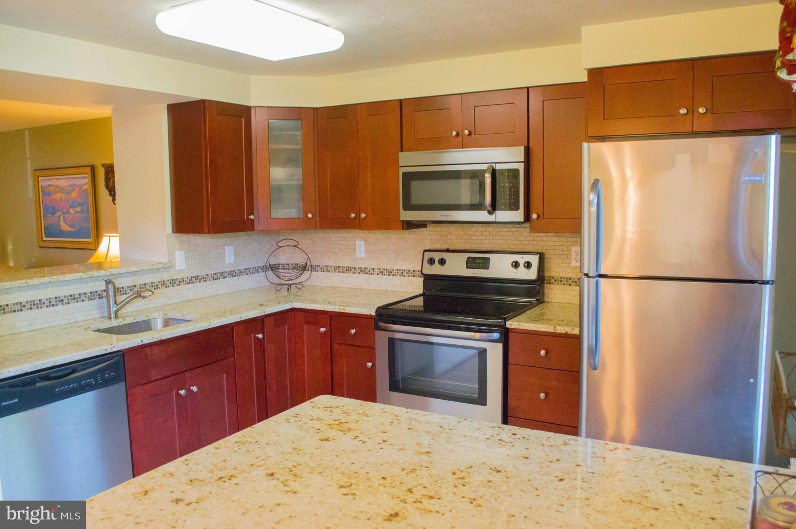 7817 Paddock Way Baltimore, MD 21244 - Photo 7 of 22 a kitchen with stainless steel appliances granite countertop a sink stove and refrigerator