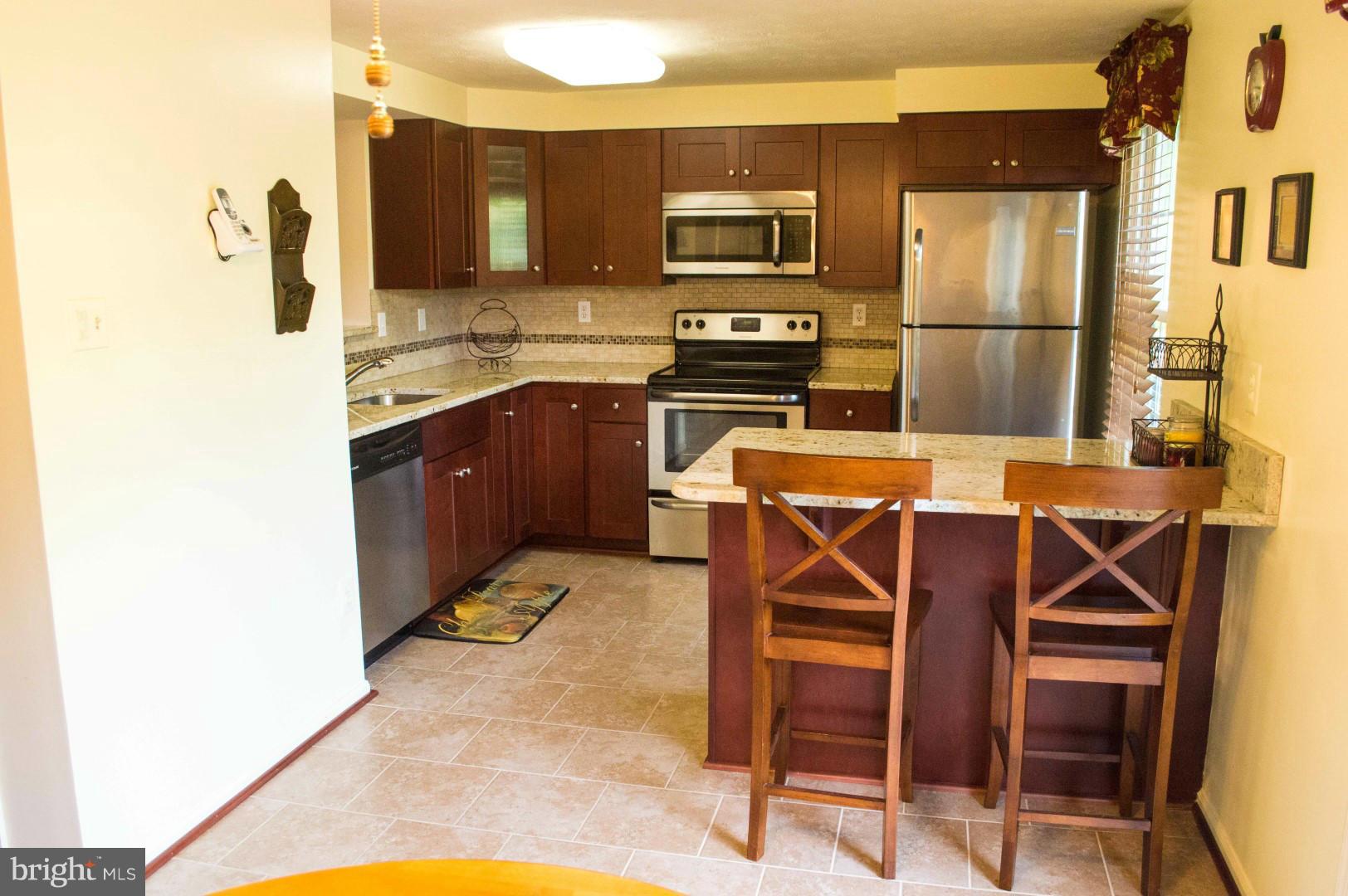 7817 Paddock Way Baltimore, MD 21244 - Photo 9 of 22 a kitchen with a refrigerator a stove top oven and a sink