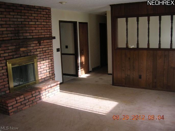 995 Doyle Road Jefferson, OH 44047 - Photo 6 of 13 The living room features a fireplace shared by the kitchen.