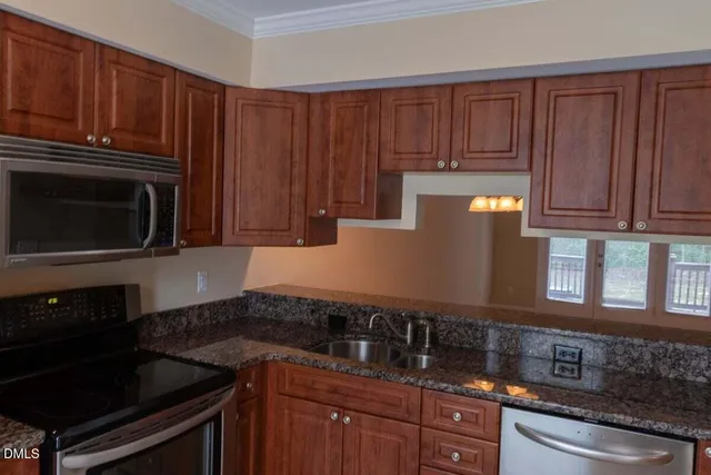 a kitchen with granite countertop wooden cabinets and a stove top oven