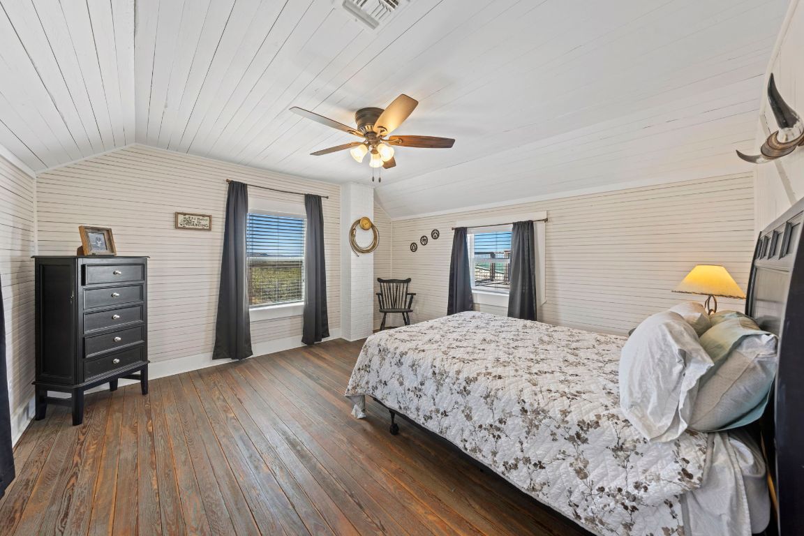 527 Walter Road Fredericksburg, TX 78624 - Photo 22 of 39 a bedroom with a bed and wooden floor