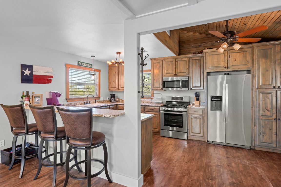 527 Walter Road Fredericksburg, TX 78624 - Photo 30 of 39 a kitchen with stainless steel appliances a stove a refrigerator and a dining table