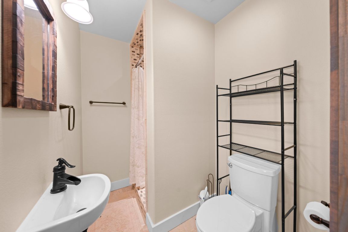 527 Walter Road Fredericksburg, TX 78624 - Photo 32 of 39 a bathroom with a sink toilet and shower