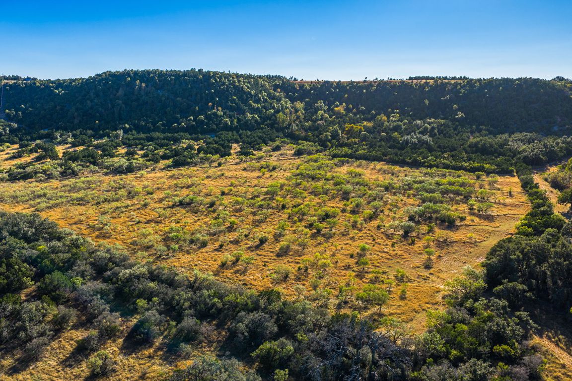 527 Walter Road Fredericksburg, TX 78624 - Photo 36 of 39 a view of a large yard with mountains in the background