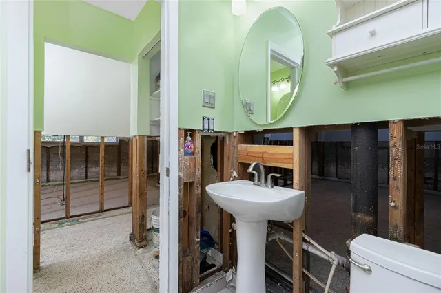 a view of a room with floor to ceiling windows and ceiling fan