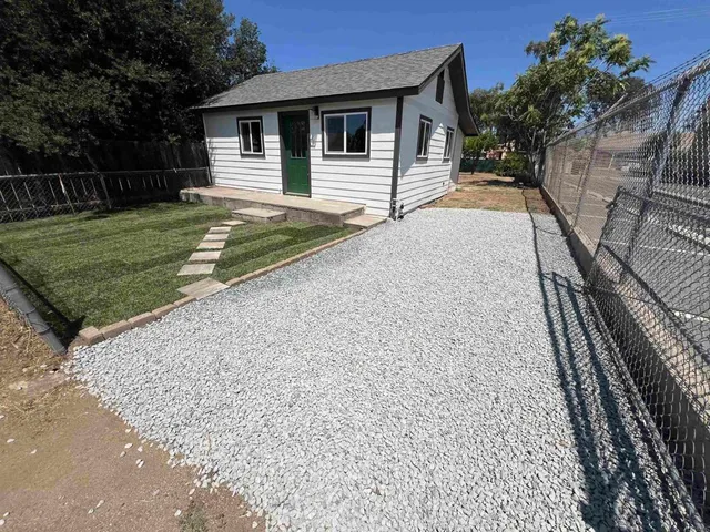a view of a house with backyard and sitting area