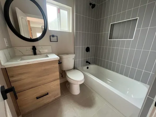 a white toilet sitting next to a bath tub