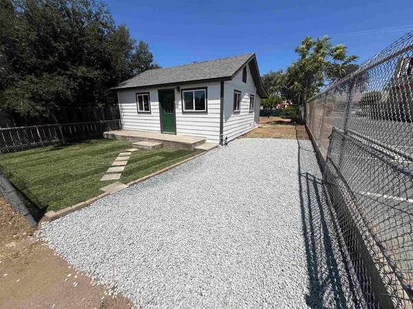 a view of a house with backyard and trees