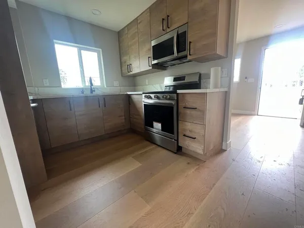 a kitchen with stainless steel appliances a stove a microwave and sink