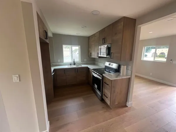 a kitchen with stainless steel appliances granite countertop a stove a sink and a refrigerator