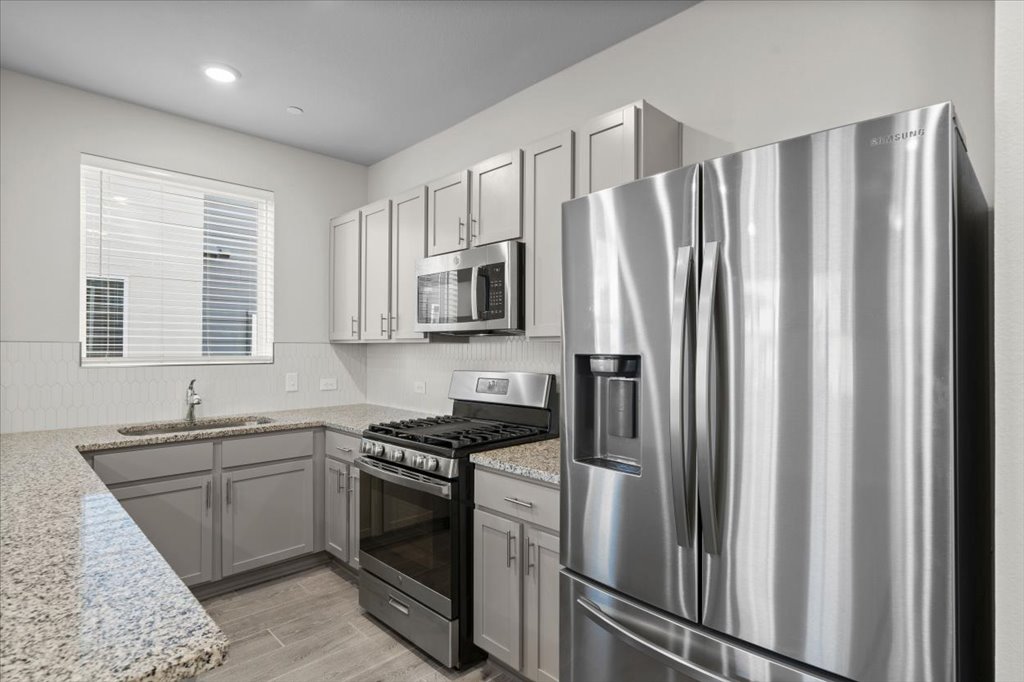 9015 Cattle Baron Path, Unit 705 Austin, TX 78747 - Photo 15 of 35 a kitchen with stainless steel appliances a refrigerator sink and cabinets