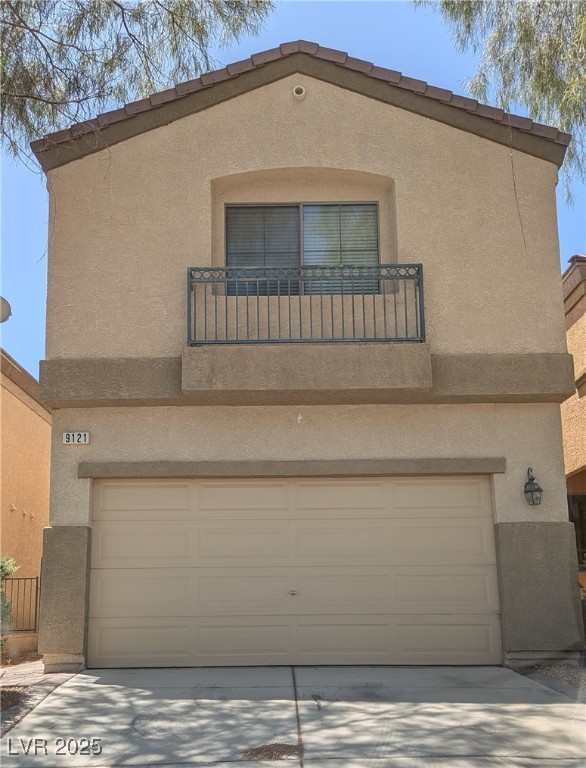 View of front of home with stucco siding, a garage, and concrete driveway