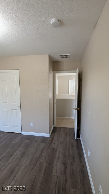 9121 Watermelon Seed Avenue Las Vegas, NV 89143 - Photo 13 of 21 Empty room featuring a smoke detector, a textured ceiling, and dark wood finished floors