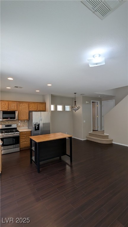 9121 Watermelon Seed Avenue Las Vegas, NV 89143 - Photo 5 of 21 Kitchen with stainless steel appliances, brown cabinetry, dark wood finished floors, backsplash, and recessed lighting