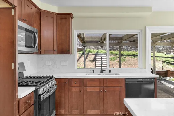 a kitchen with stainless steel appliances a stove a sink and a microwave