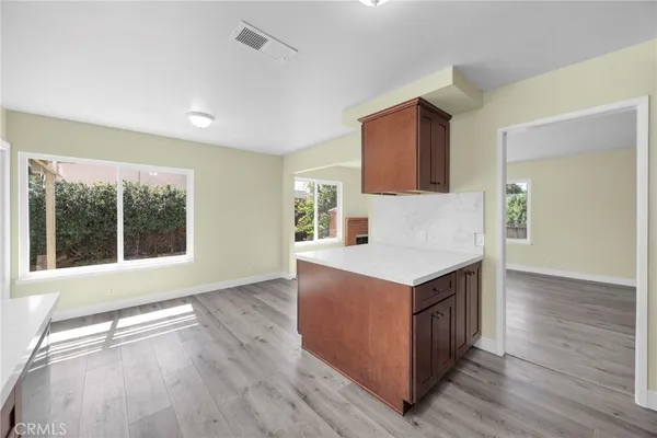a kitchen with a stove and a white cabinets with wooden floor