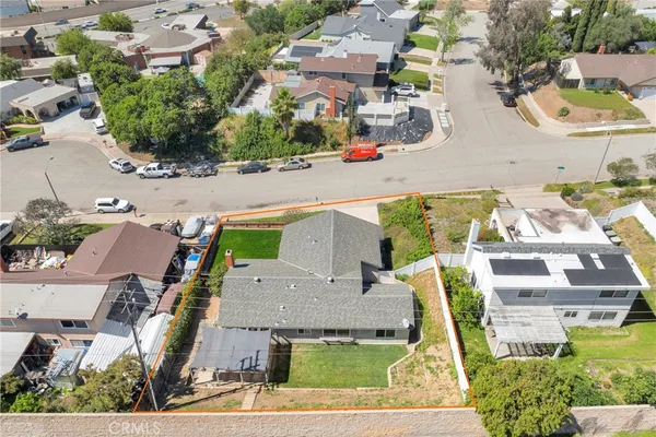 an aerial view of residential houses with outdoor space and parking