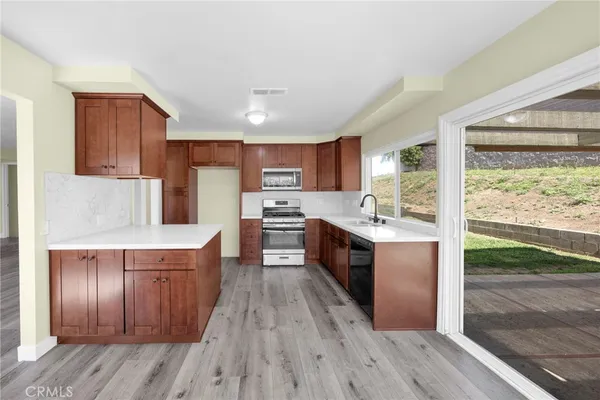 a kitchen with wooden floors and wooden cabinets