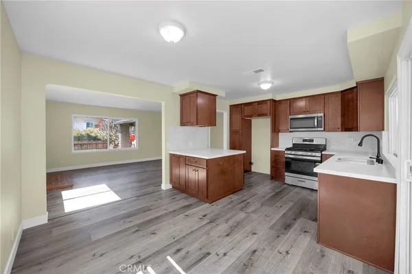 a large kitchen with stainless steel appliances granite countertop a stove a sink and a microwave