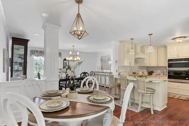 a kitchen with stainless steel appliances kitchen island granite countertop a refrigerator a sink a stove and white cabinets