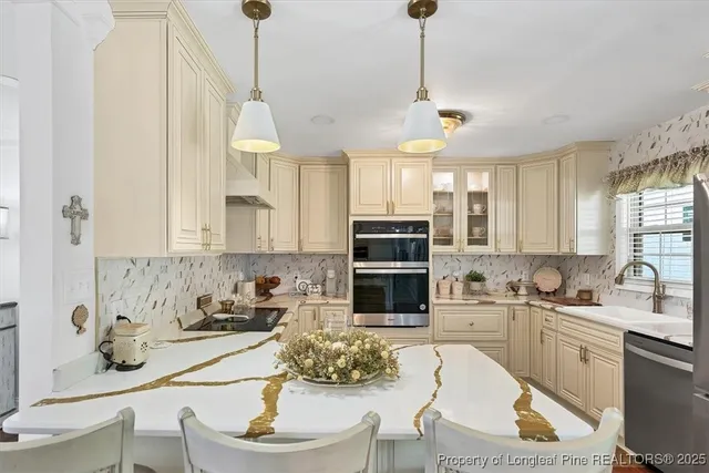 a kitchen with a sink dishwasher a stove and white cabinets with wooden floor
