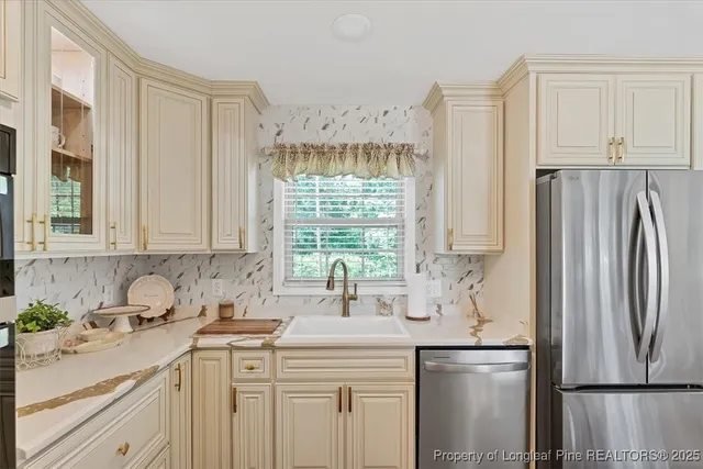 a kitchen with stainless steel appliances a refrigerator sink and cabinets