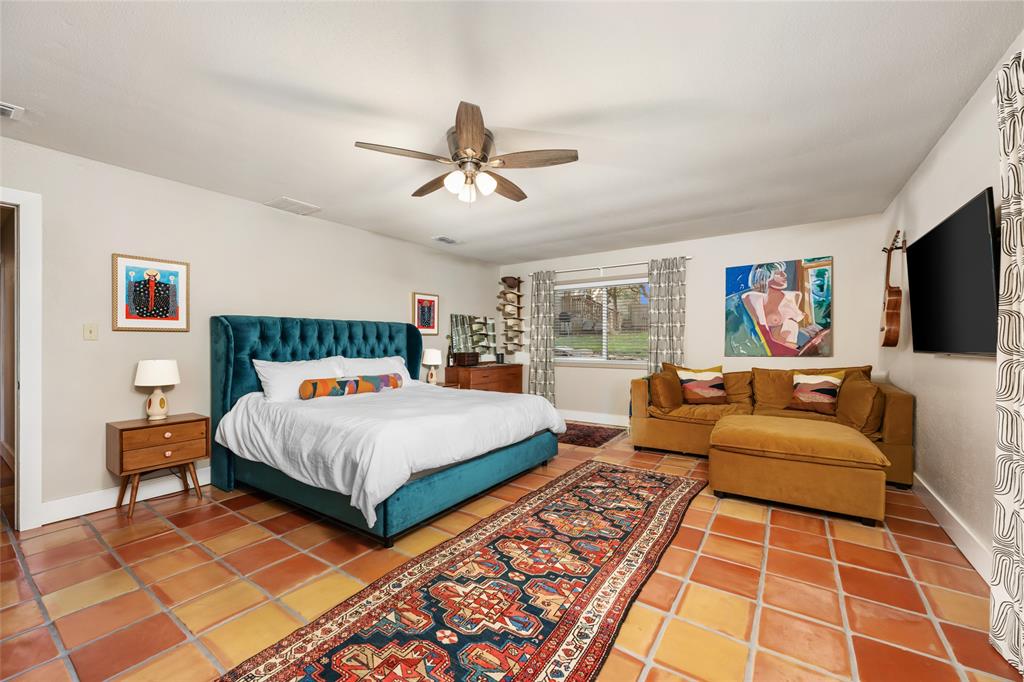 2210 Red Fox Road Austin, TX 78734 - Photo 25 of 40 An inviting sleeping area features terracotta tile flooring, a large window, and a convenient ceiling fan for comfort.