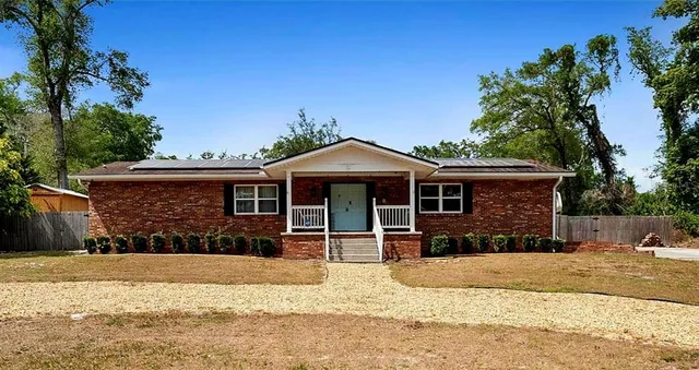 a front view of a house with a yard covered with snow