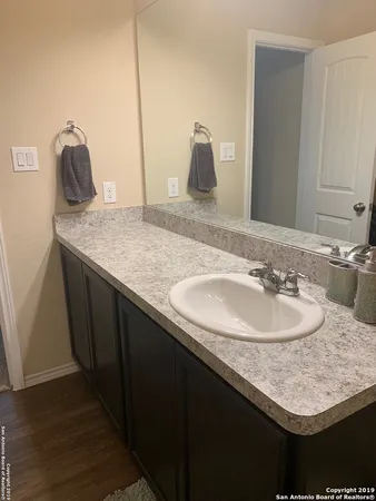 a bathroom with a granite countertop sink and a mirror