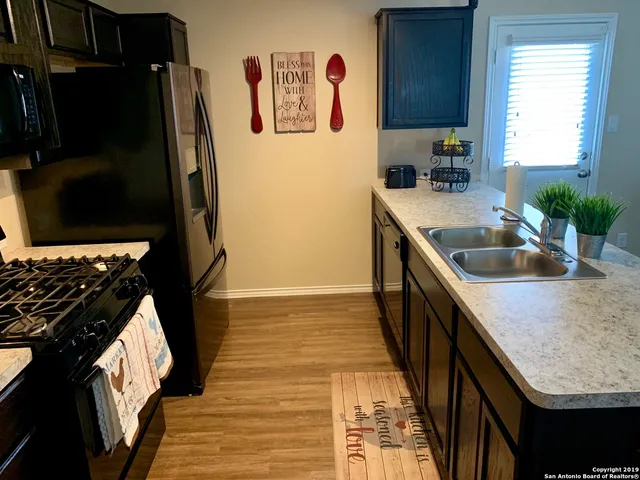 a kitchen with granite countertop stainless steel appliances a sink stove and refrigerator