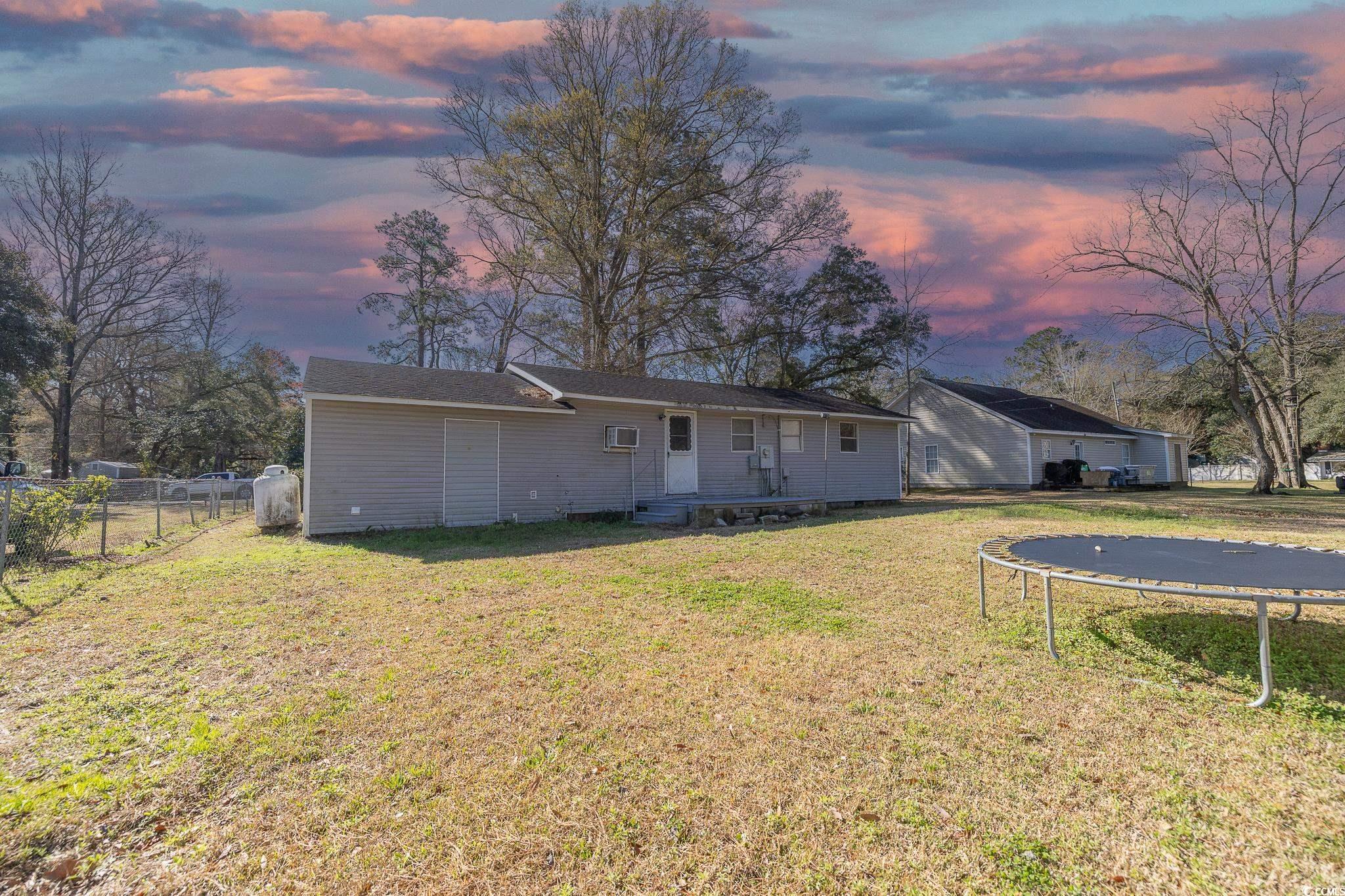 101 County Rd S-22-732 Georgetown, SC 29440 - Photo 4 of 17 Back of property at dusk featuring a lawn, a tramp