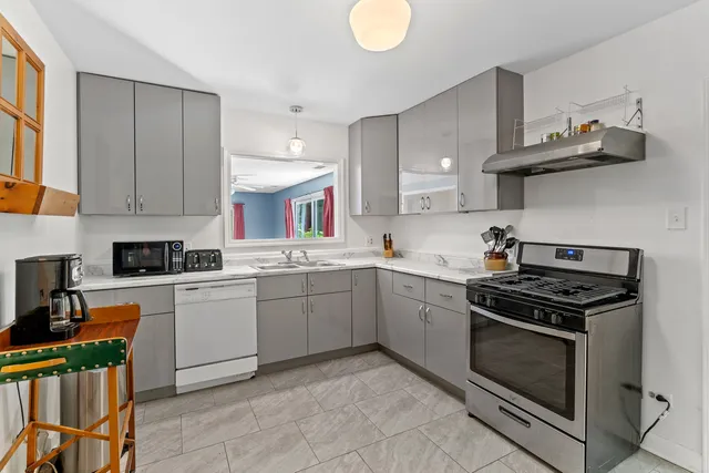 a kitchen with a stove sink and cabinets