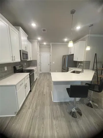 a kitchen with kitchen island granite countertop a sink a counter space stainless steel appliances and cabinets