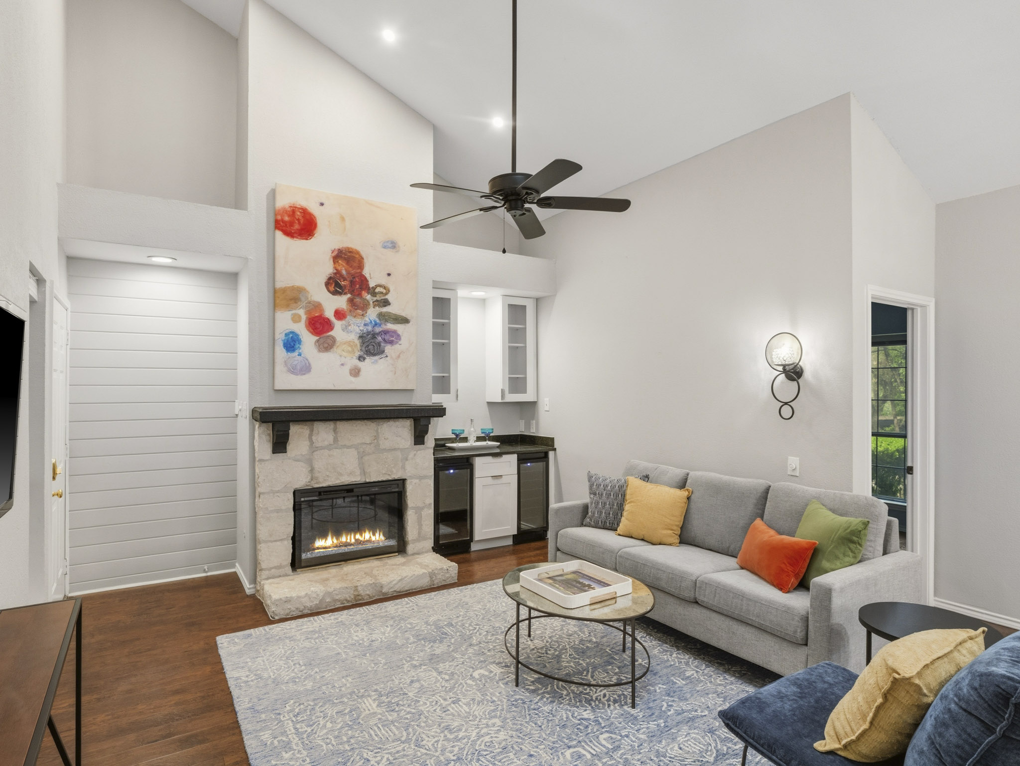 3809 Spicewood Springs Road, Unit 137 Austin, TX 78759 - Photo 2 of 34 A spacious living area offers vaulted ceilings and a cozy stone fireplace, perfect for relaxation.