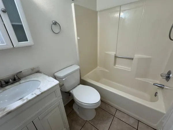 a white toilet sitting next to a bath tub