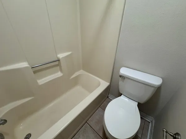 a white toilet sitting next to a bath tub