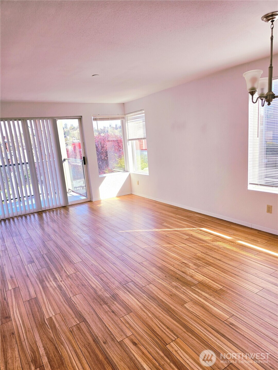 3022 Southwest Bradford Street, Unit 210 Seattle, WA 98126 - Photo 3 of 17 wooden floor in an empty room with a window