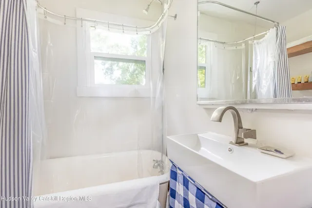 a bathroom with a sink a mirror and a bathtub