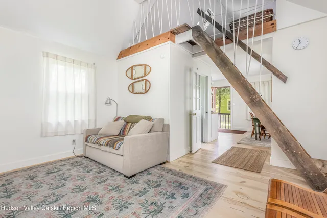 a view of a bedroom with wooden floor and white walls