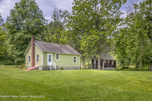 a view of a house with a yard and wooden fence