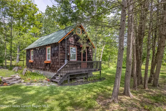 a view of a lush green field with a house in the background