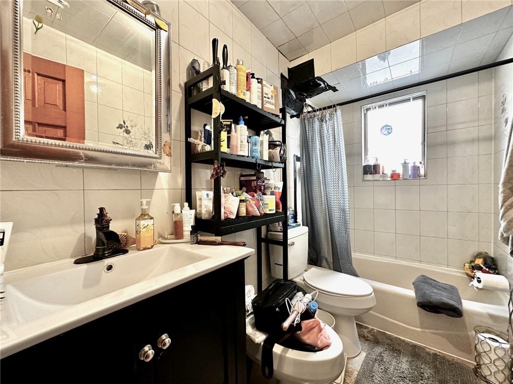 1453 85th Street Brooklyn, NY 11228 - Photo 12 of 18 a bathroom with a sink vanity mirror and toilet
