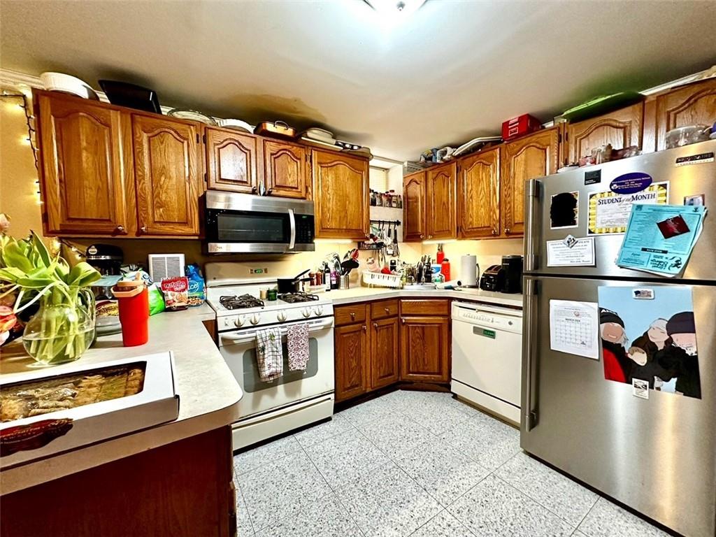 1453 85th Street Brooklyn, NY 11228 - Photo 8 of 18 a kitchen with stainless steel appliances granite countertop a stove top oven a sink dishwasher and cabinets with wooden floor
