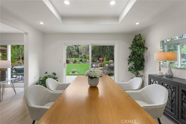 a view of a dining room with furniture a kitchen and chandelier