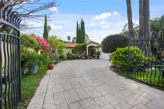 a view of a white house with a yard and plants